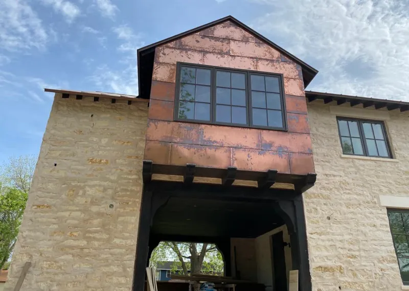 Copper metal panel facade on a stone building for Metal Roof Coating in Grain Valley